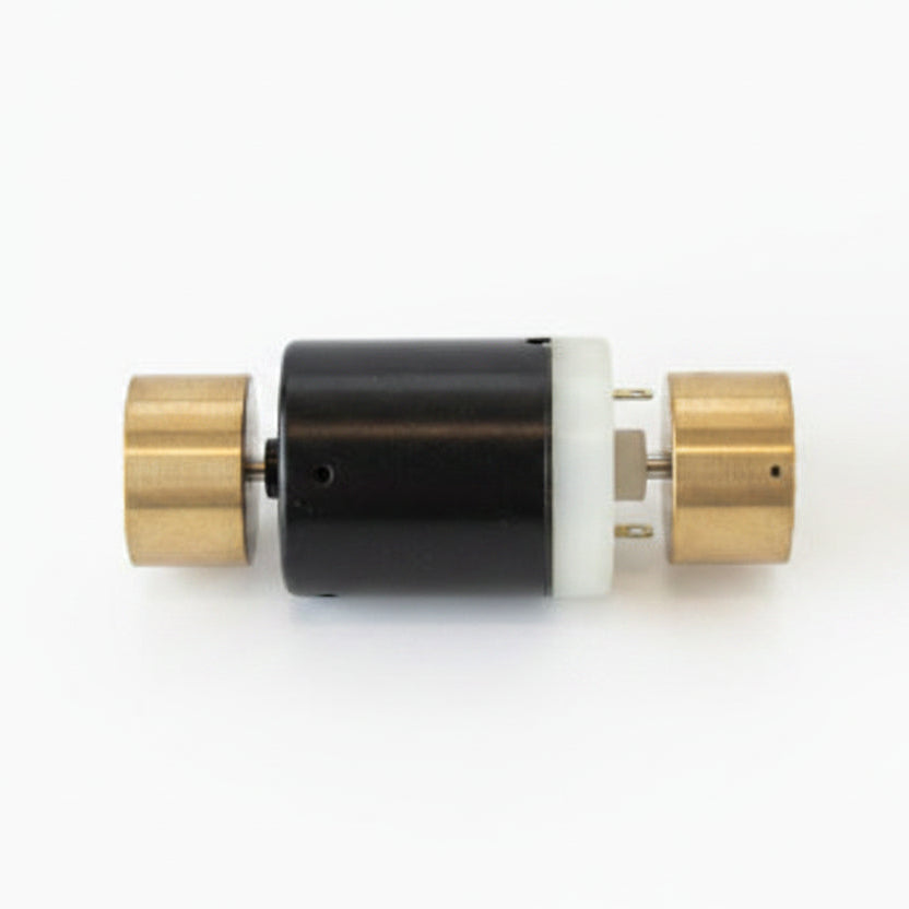 A small cylindrical metal component with a black center body, white end section, and brass-colored side fittings, sealed in clear plastic packaging on a white background.